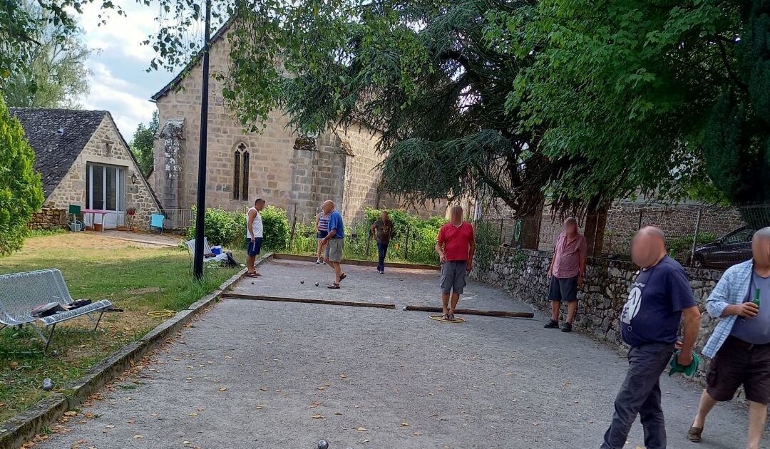 Photo d'habitants jouant à la pétanque sur le terrain de boule du jardin public à la roche-canillac