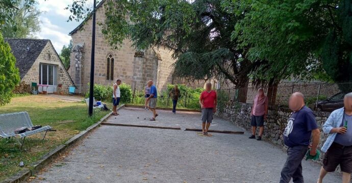 Photo d'habitants jouant à la pétanque sur le terrain de boule du jardin public à la roche-canillac